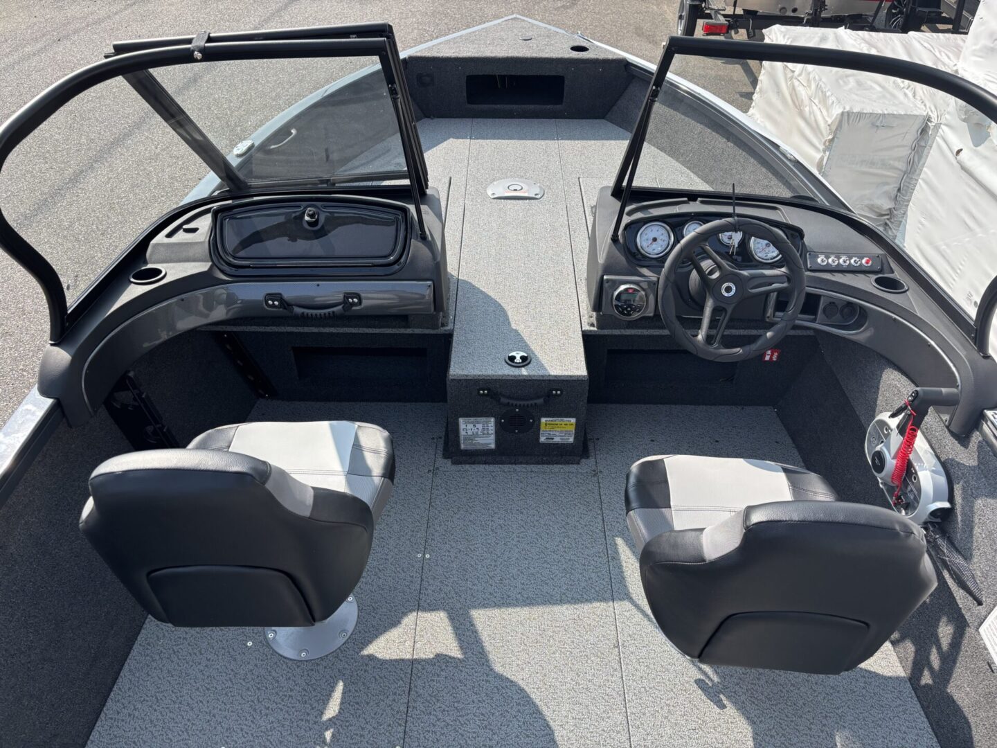 Interior view of a boat's cockpit with two seats and open windshield.