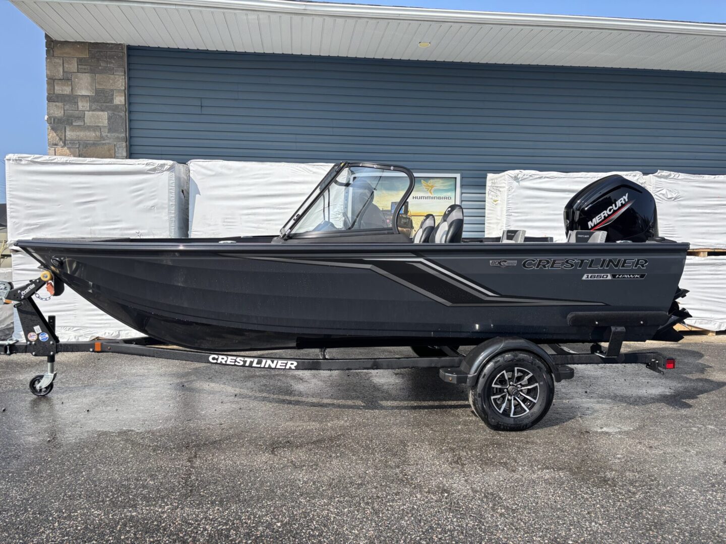 Sleek black fishing boat on a trailer with outboard motor.