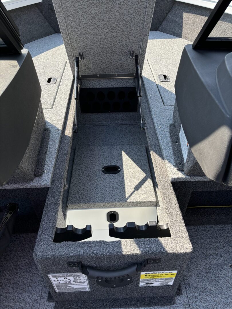 Open storage compartment between boat seats on a sunny day.