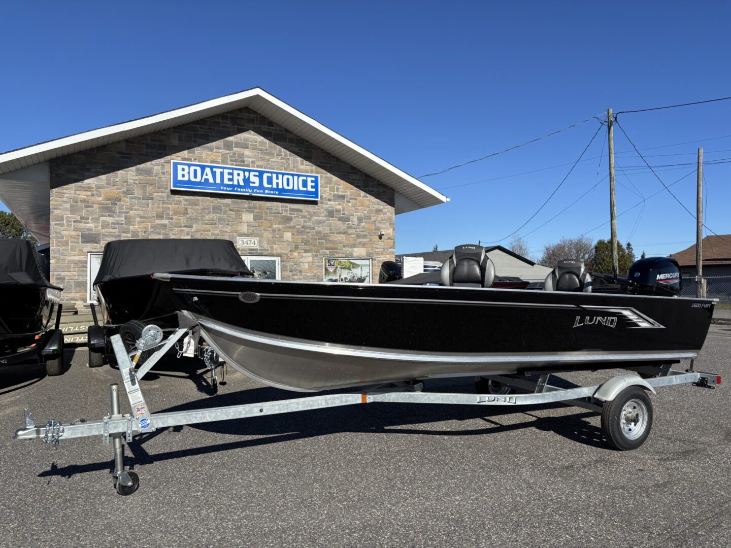 Black and white boat on a trailer parked outside a Boater's Choice store.