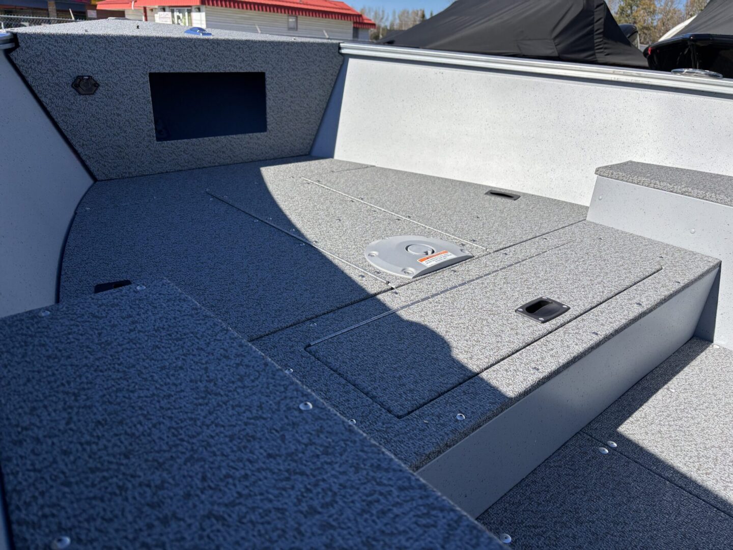 Empty fishing boat deck with storage compartments and clean surface.