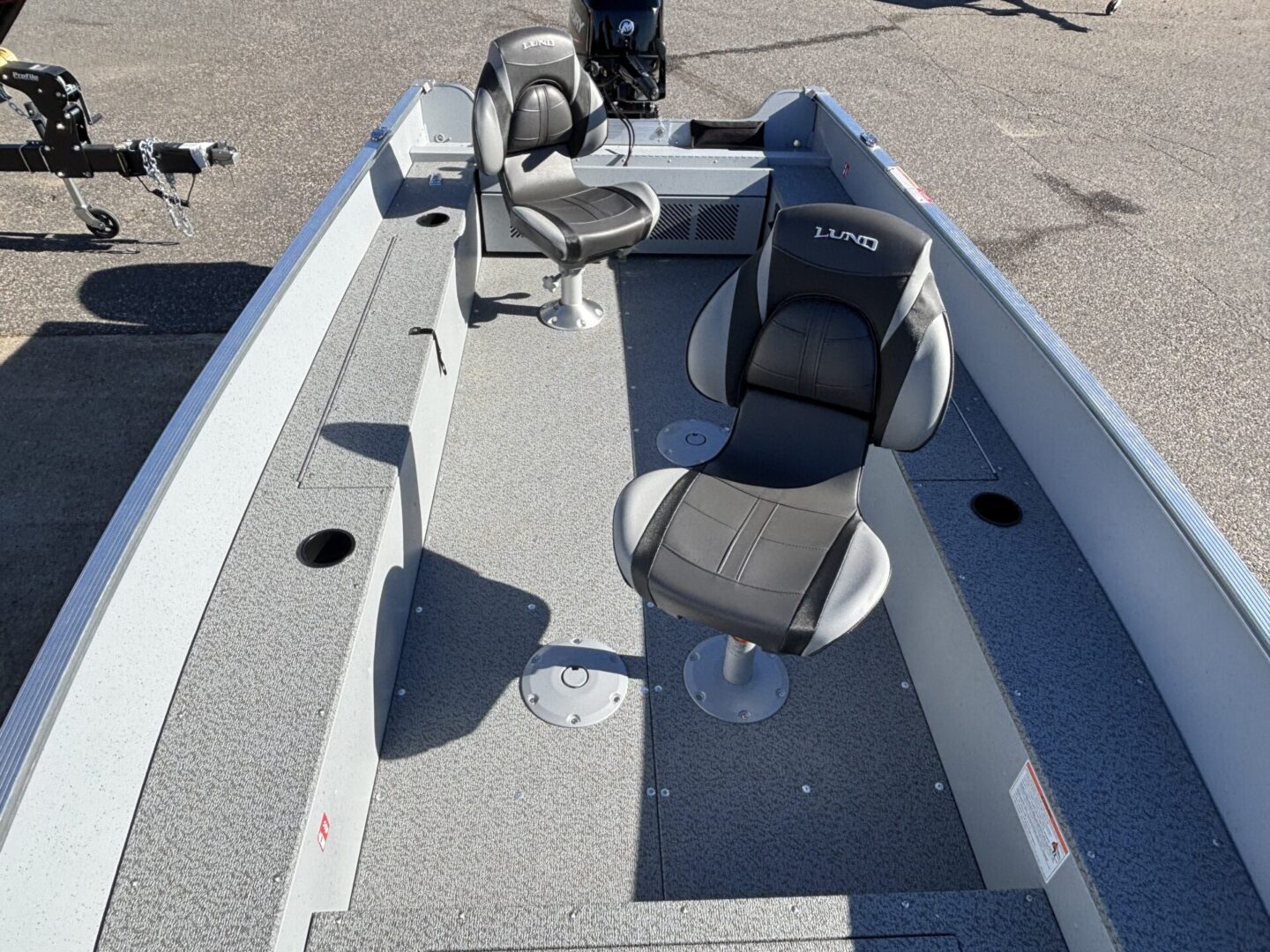 Interior view of a fishing boat with swivel seats and a steering console.