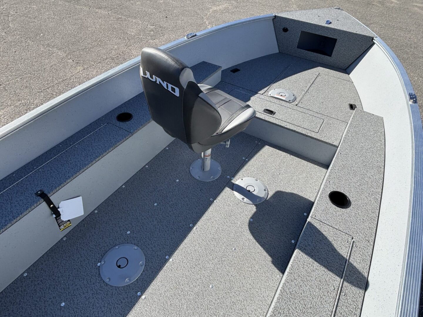 Interior of a small fishing boat with swivel chair and storage compartments.