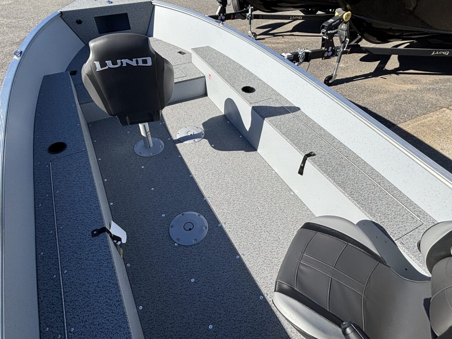 Spacious boat deck with seating and a mounted fishing rod holder.