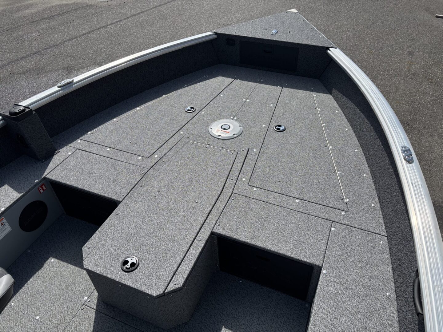 Close-up of a gray carpeted boat deck with storage compartments.