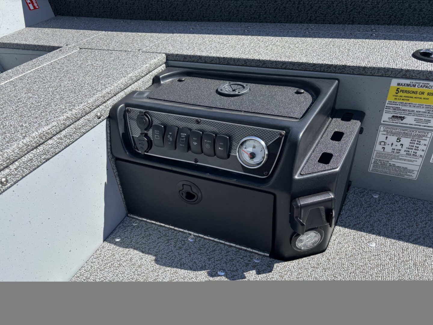 A black portable grill with a dial and handles on a gray surface.