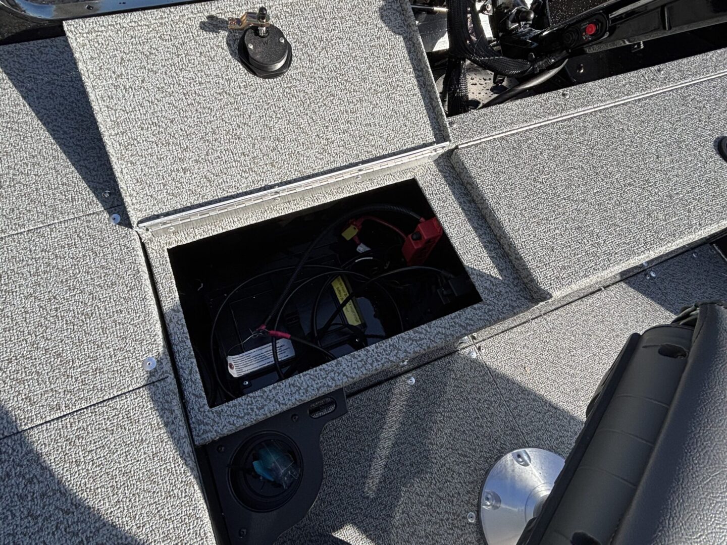 Open compartment on a speckled surface showing stored items.