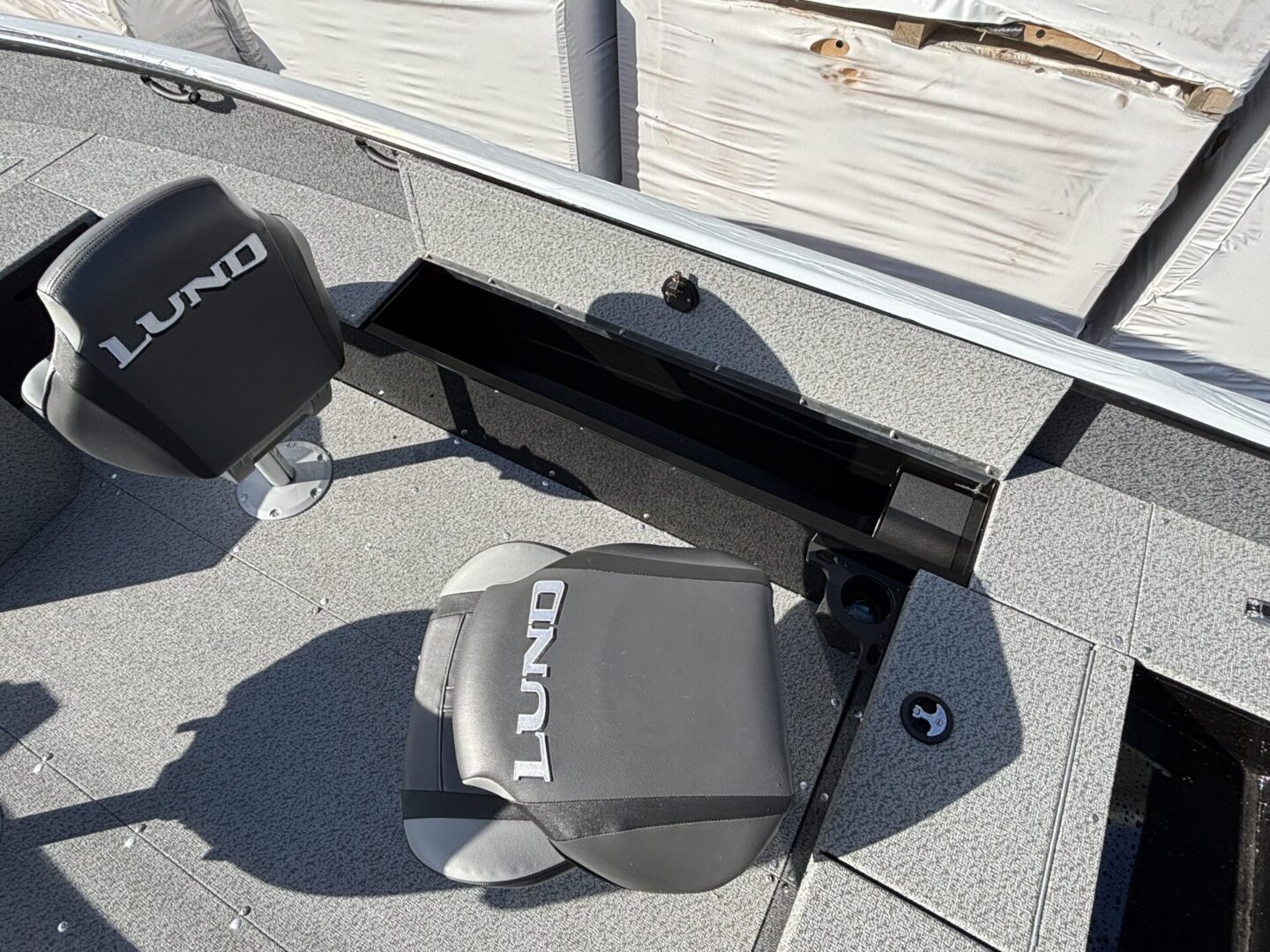 Two Lund branded boat anchors mounted on a boat deck.