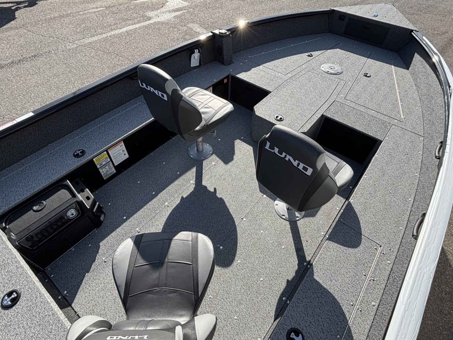 Two black fishing seats installed on a boat deck under sunlight.