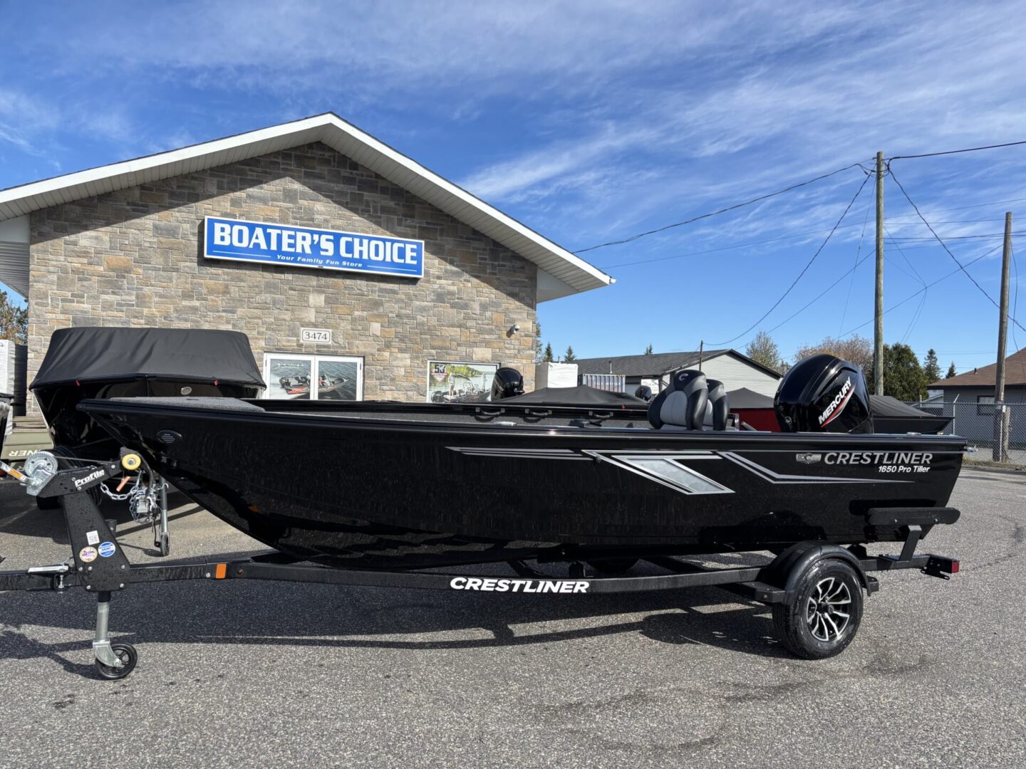 Black Crestliner fishing boat parked outside a building.