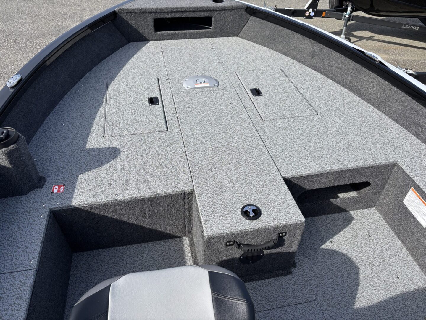 Interior of a fishing boat with carpeted deck and storage compartments.