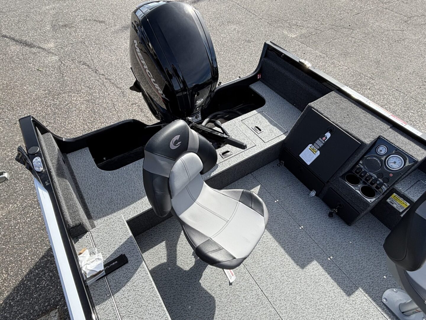 Boat cockpit with a swivel chair and outboard motor.