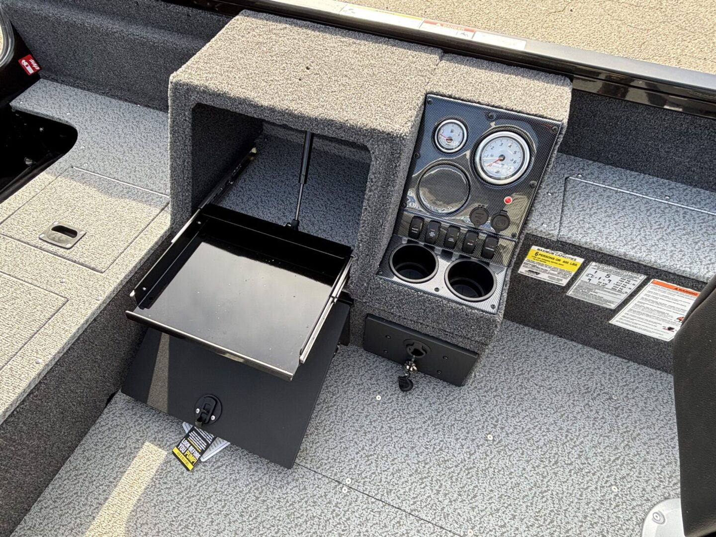 Vehicle console with cup holders and a small refrigerator.