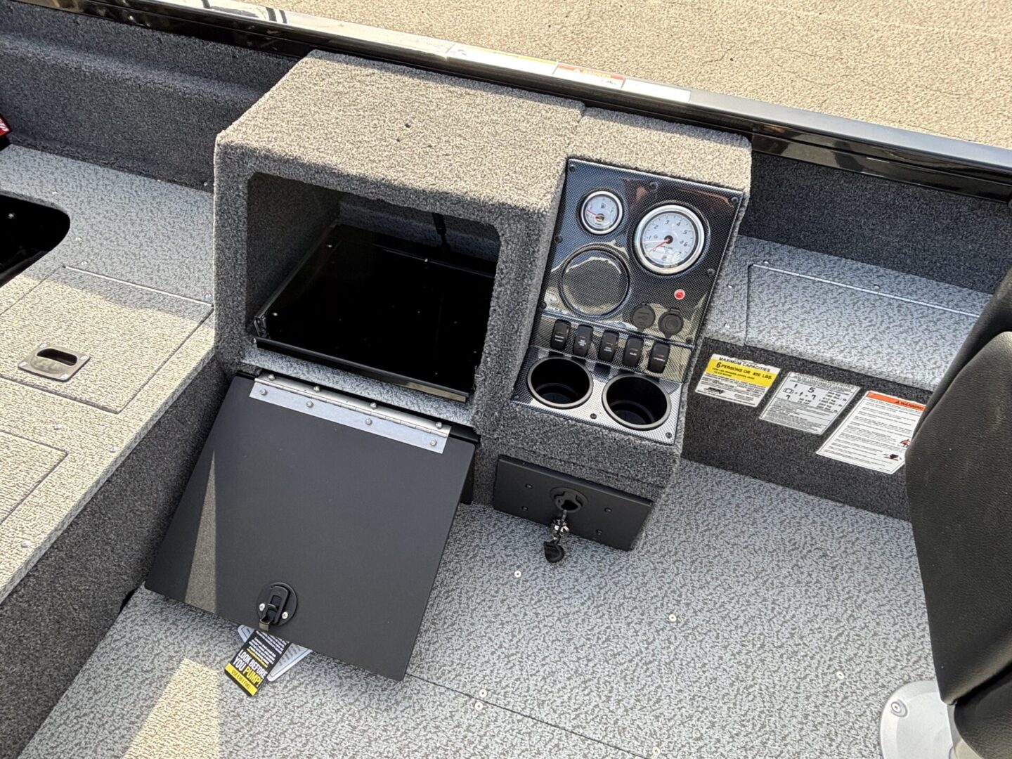 Open boat storage compartment with control panel and gauges.