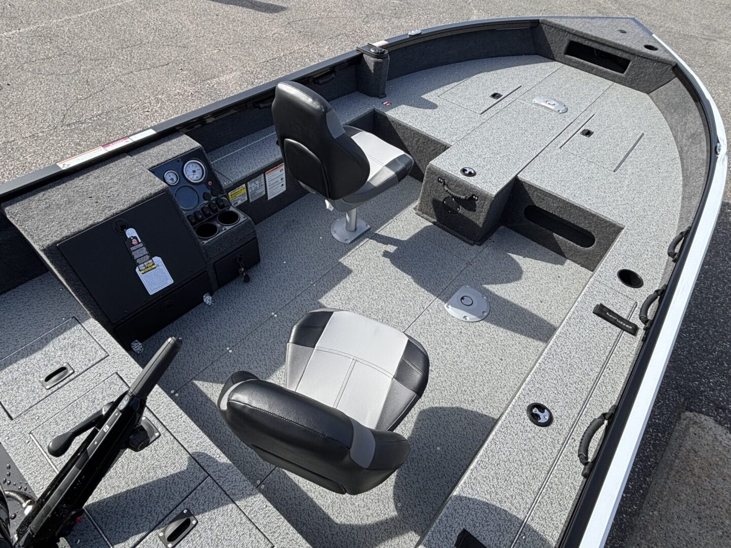 Interior view of a boat's cockpit with seating and controls.