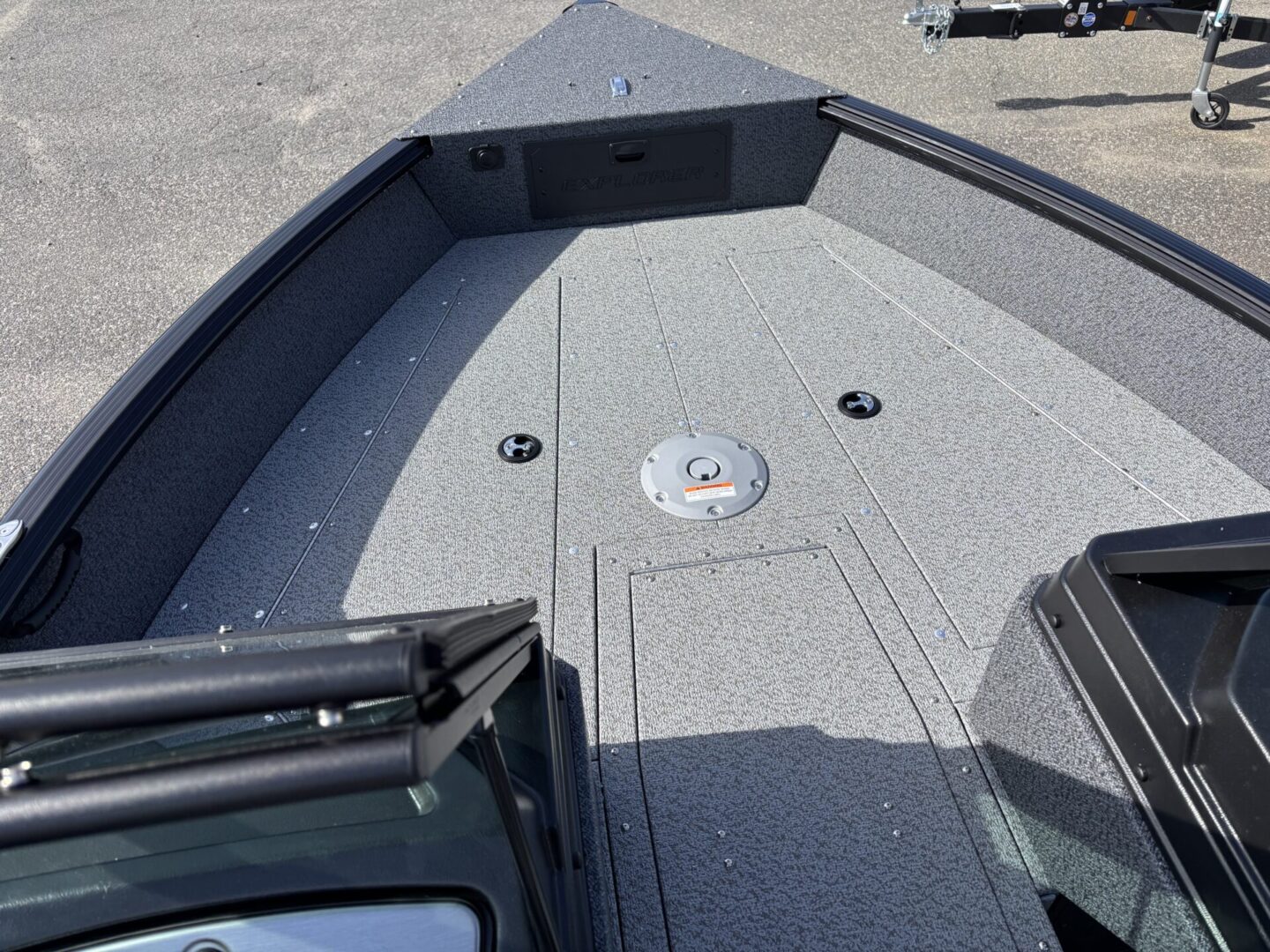 Bow deck of a fishing boat with storage compartments and a fishing seat.