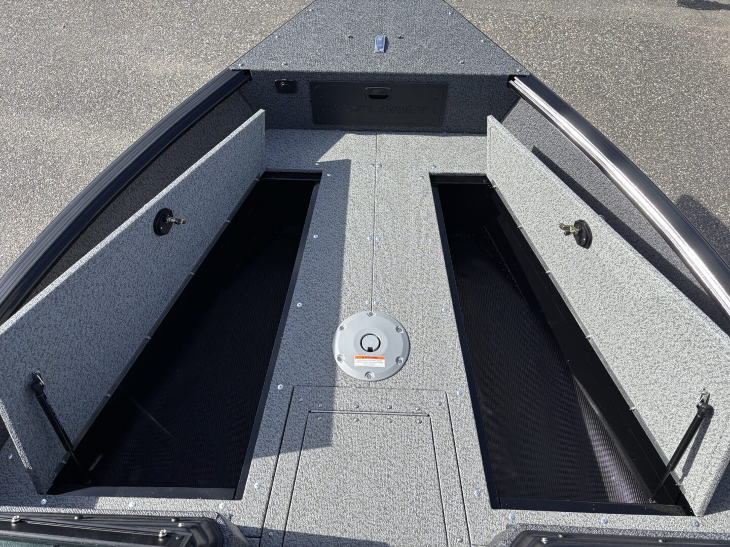 Open compartments in a boat's deck revealing storage space.