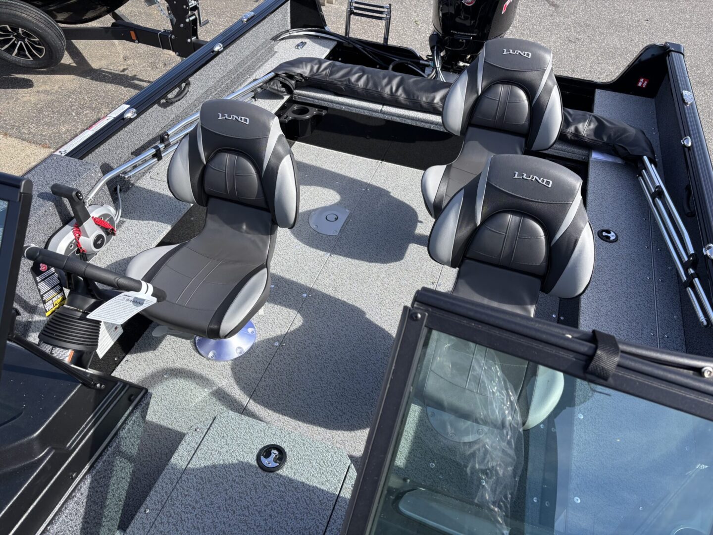 Four cushioned boat seats arranged inside a fishing boat.