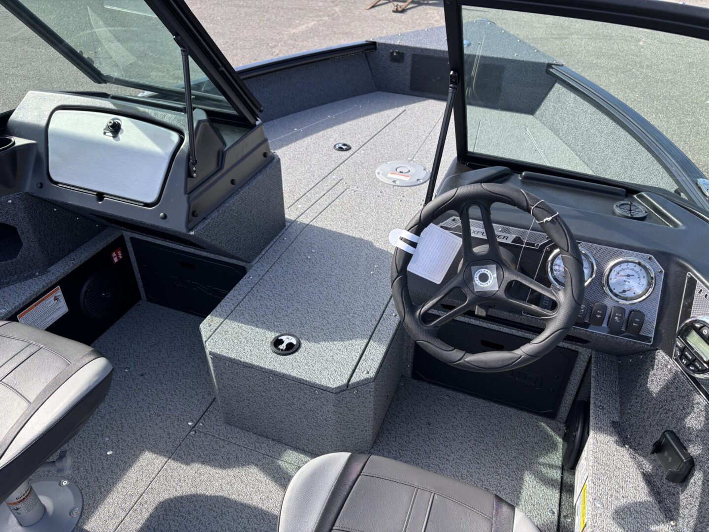 View of a boat's helm and seating area with modern controls.