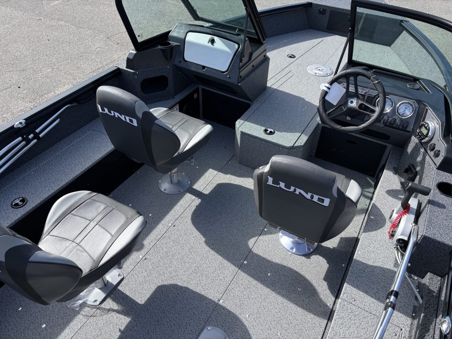 Interior view of a fishing boat with two seats and a steering console.
