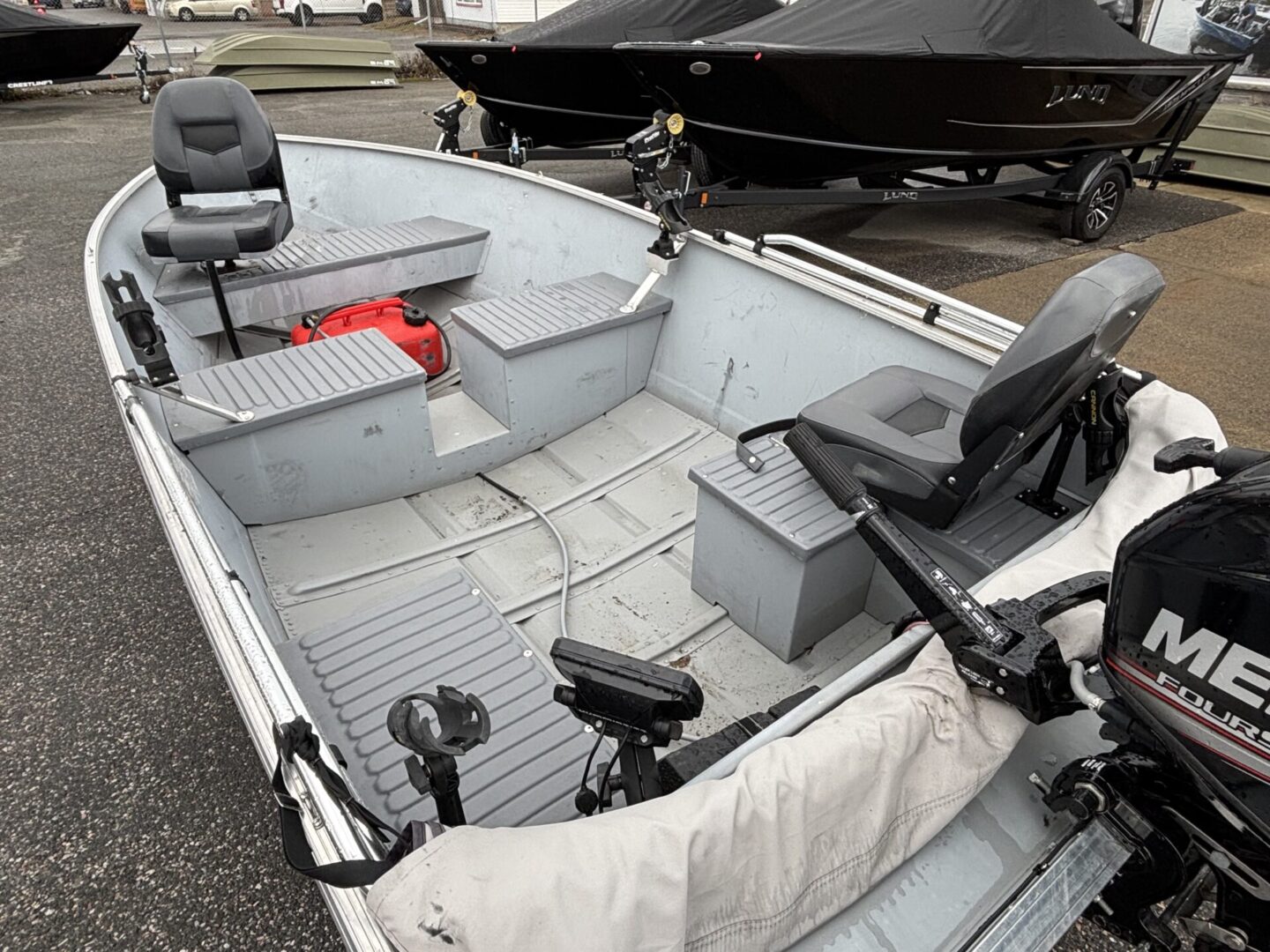 Interior view of a small fishing boat with seats and storage compartments.