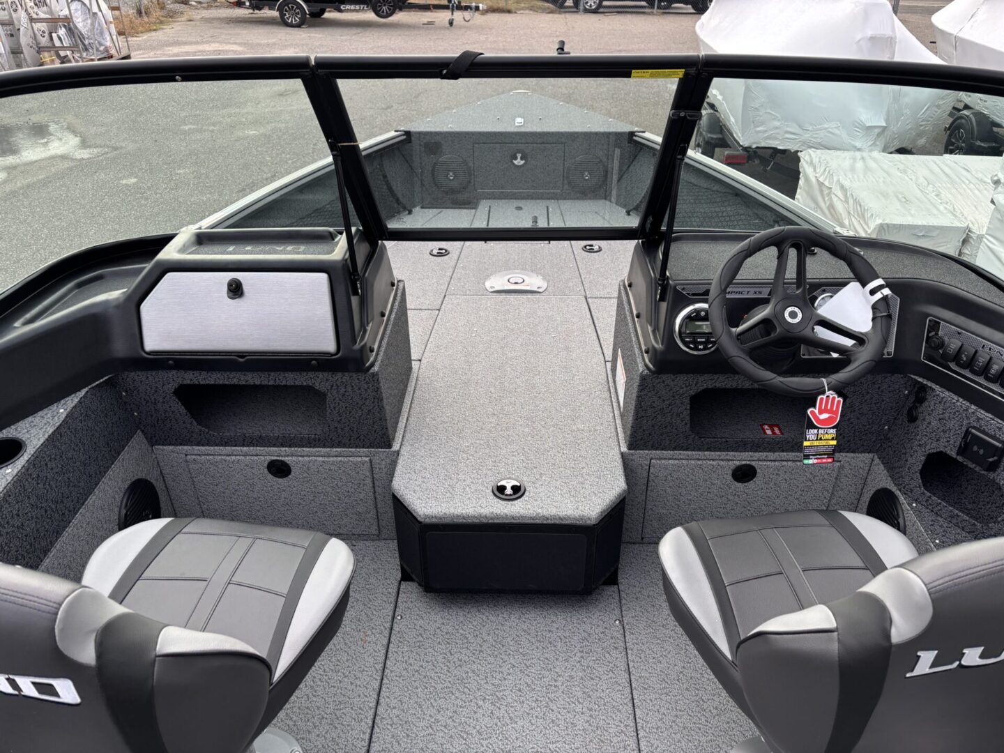 Interior view of a modern fishing boat with seating and steering console.