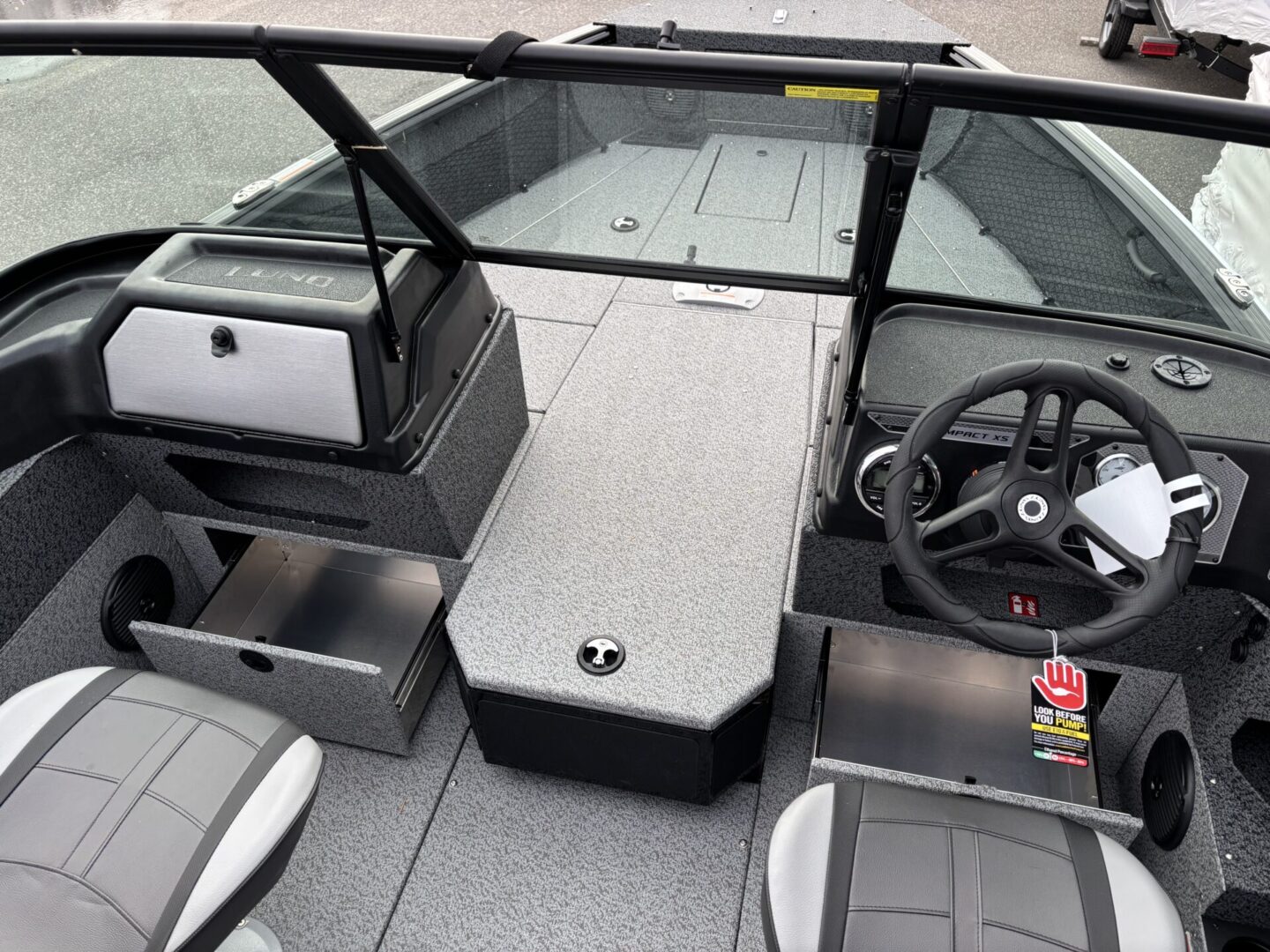Interior view of a modern boat with steering wheel and cushioned seats.