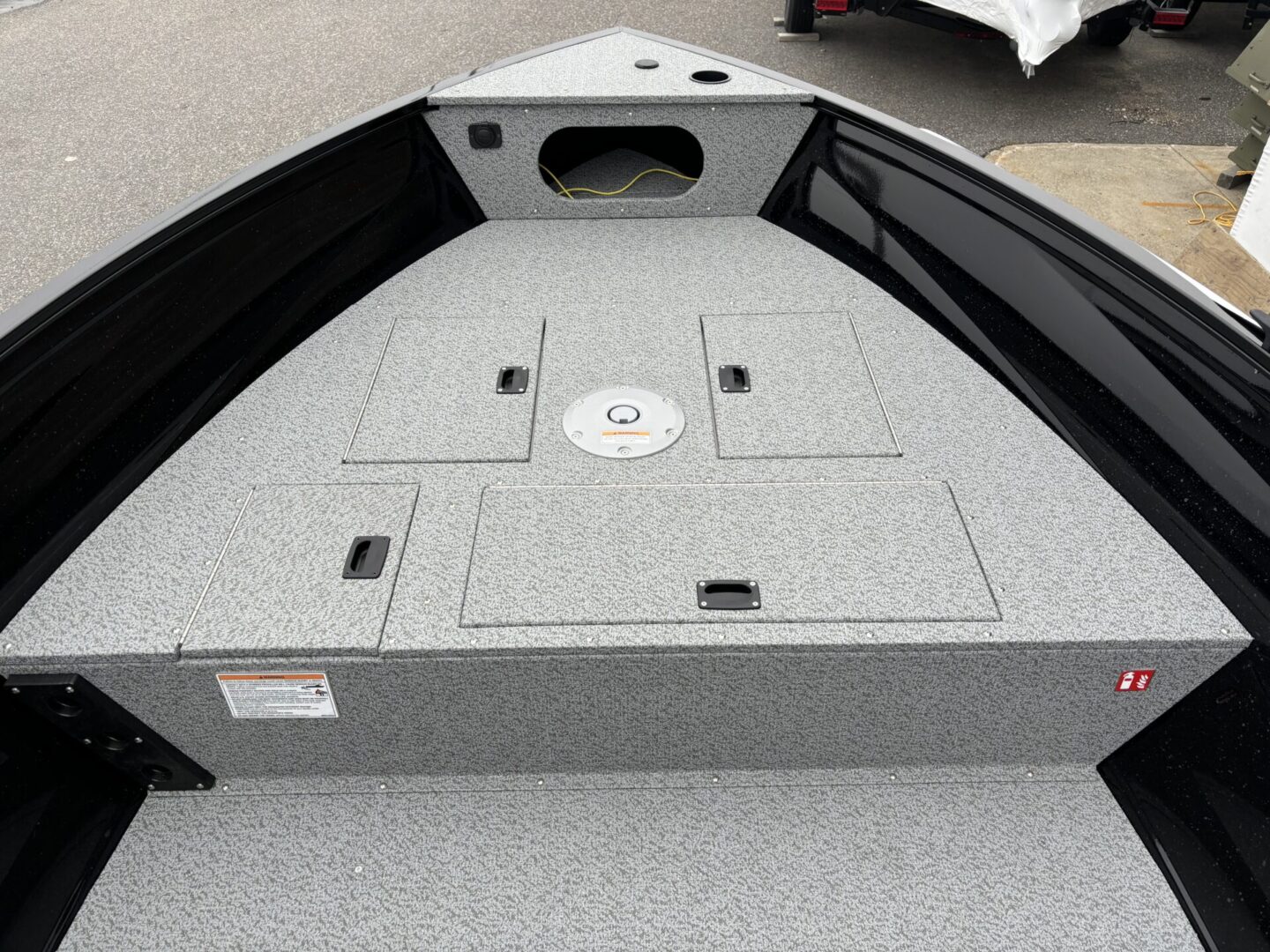 Front deck of a fishing boat with storage compartments and a hatch.