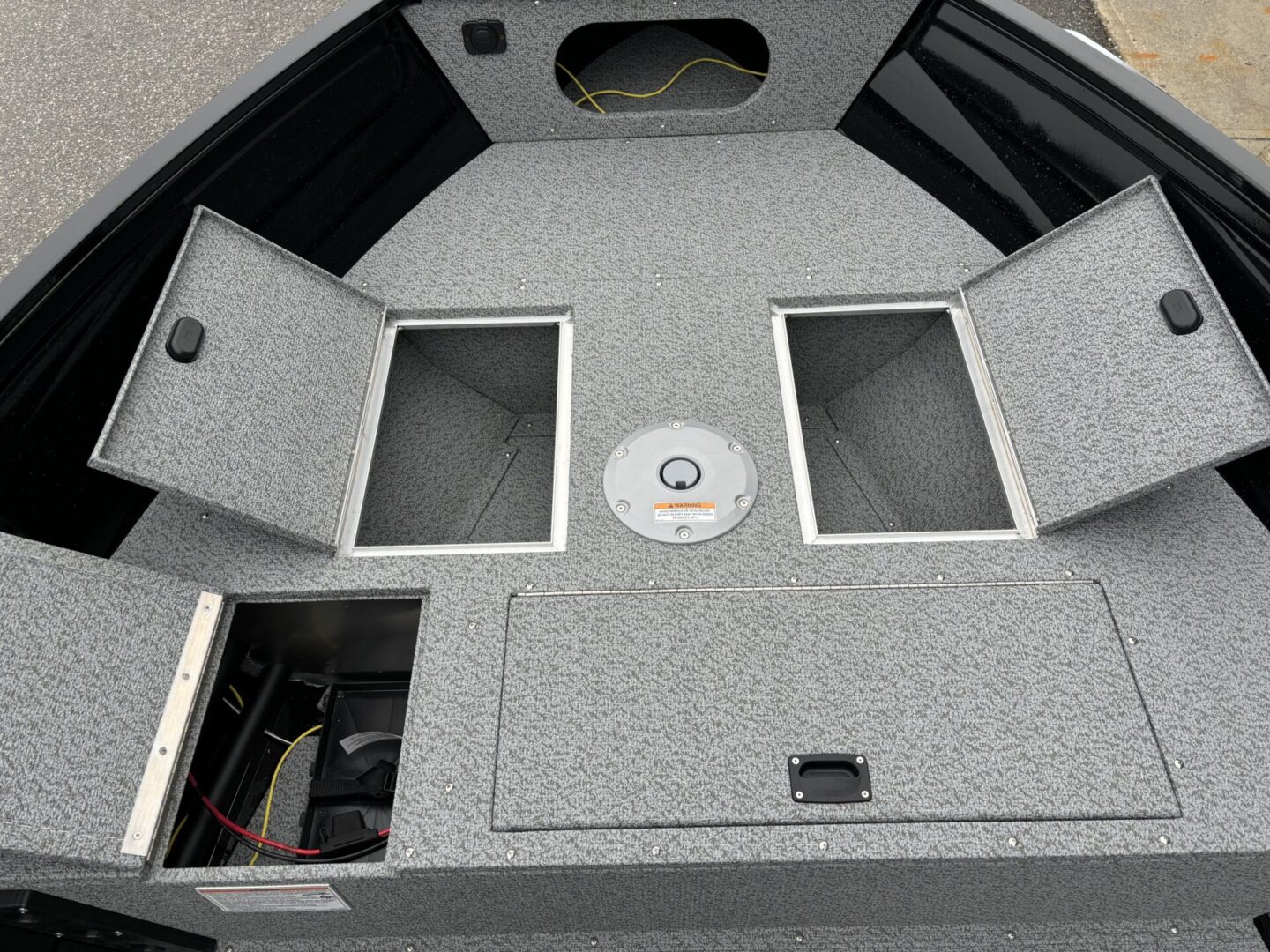 Empty carpeted storage compartments on a boat deck.