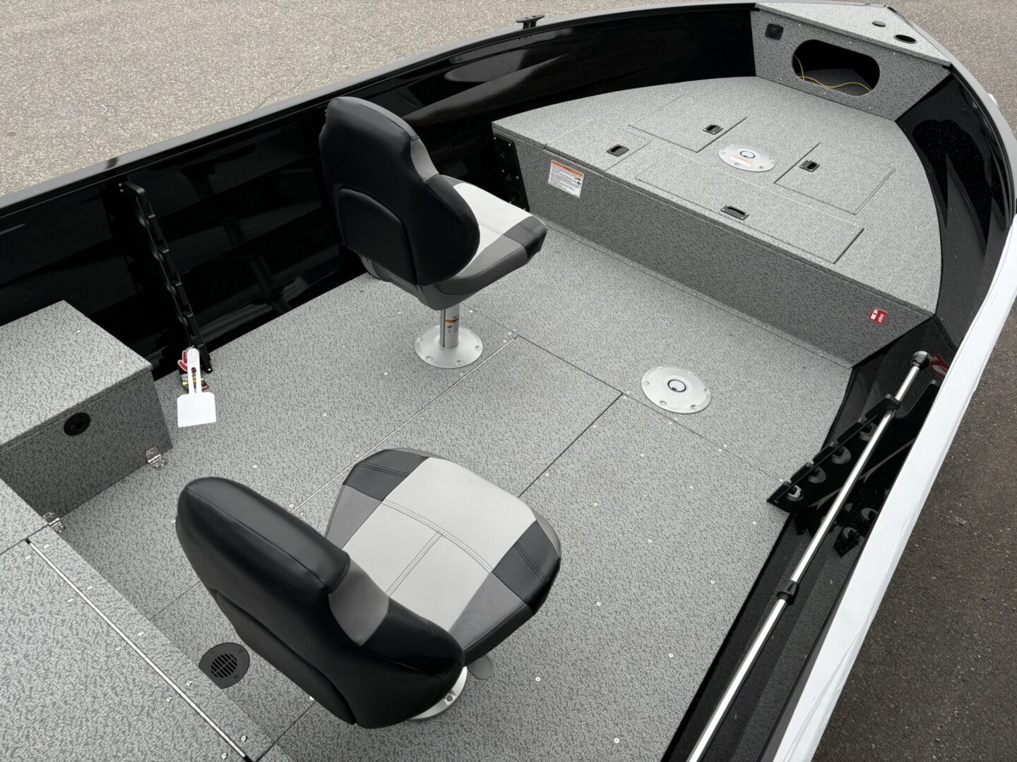 Interior of a modern fishing boat with two seats and storage compartments.